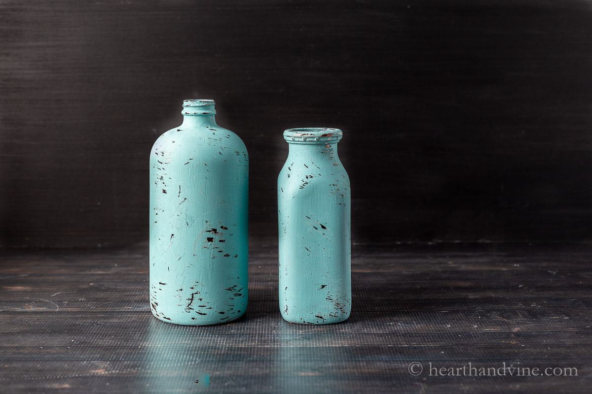 Completed painted and distress bottles with blue paint.