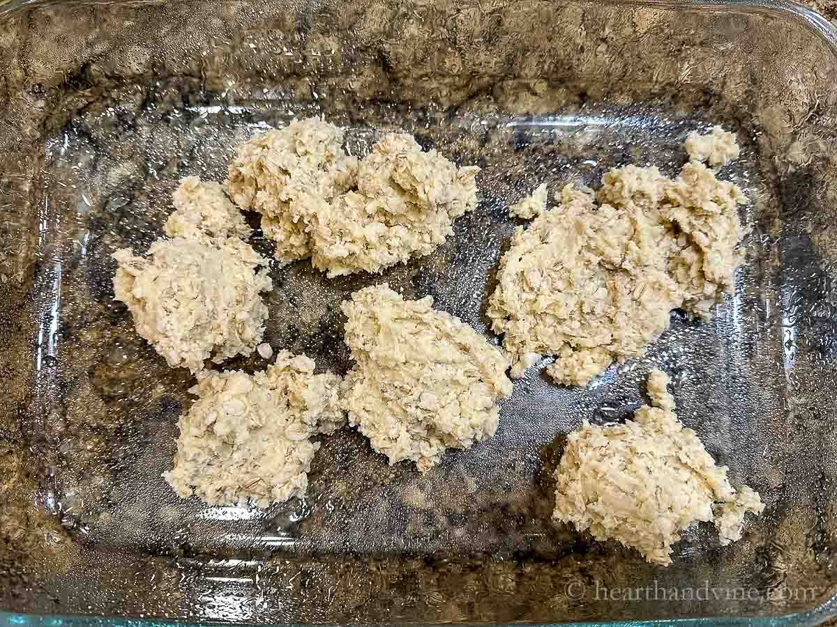 Dollops of the crust mix in a 9 x 13 inch pan.