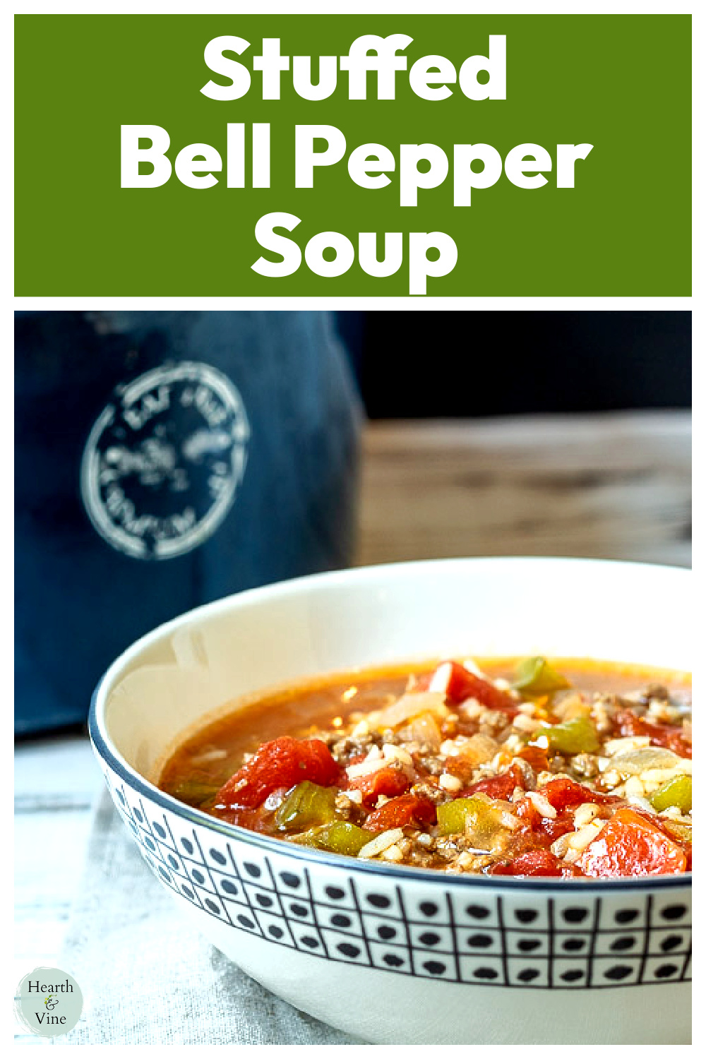 Partial view of a bowl of stuffed pepper soup with a pot behind it.