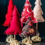 Grouping of five tabletop stuffed fabric Christmas trees.
