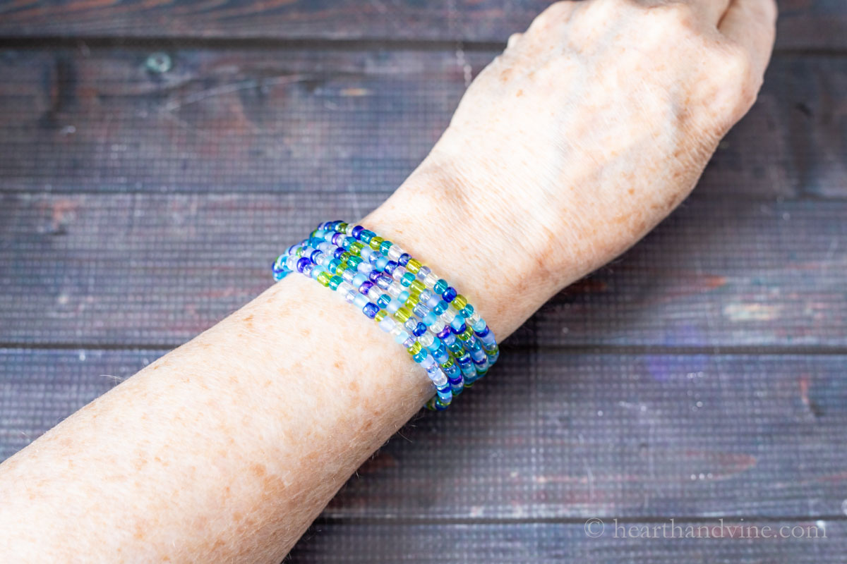 Seed bead multi-strand memory wire bracelet on a wrist.