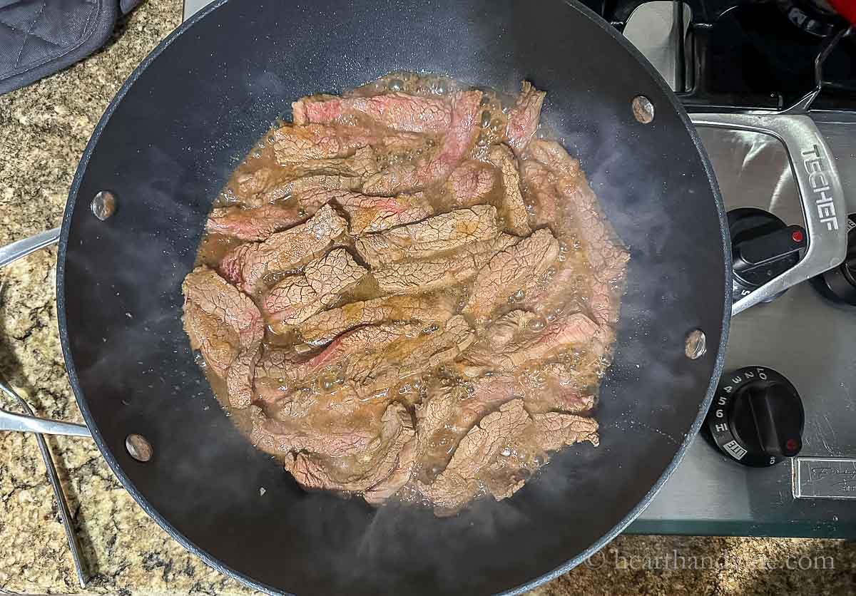 Marinated beef strips cooked in the skillet.