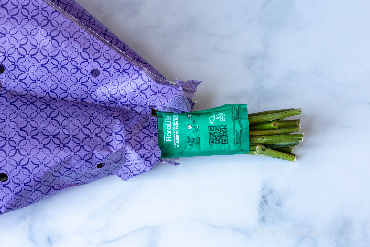 End of a store bouquet showing a packet of floral food attached at the end.