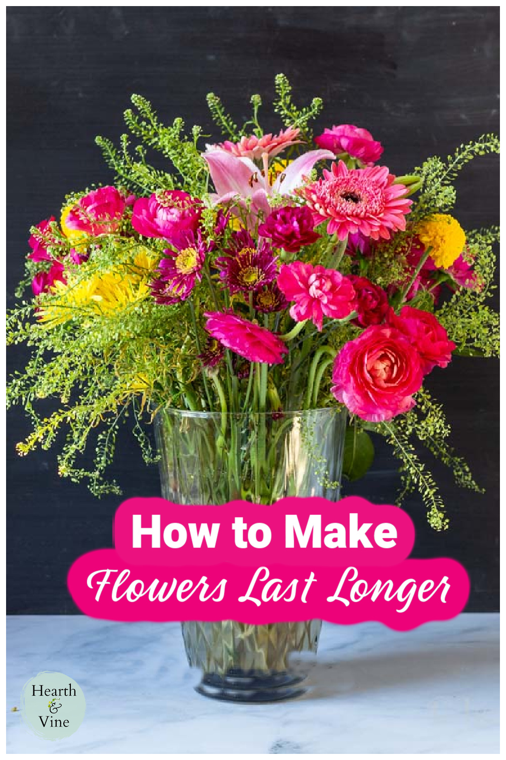 Large vase will with a variety of flowers including gerbera daisies, pink roses, a lily, ranunculus and a green filler.