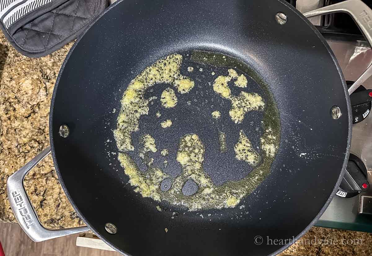 Grated garlic and ginger sauteed in a large skillet in oil.