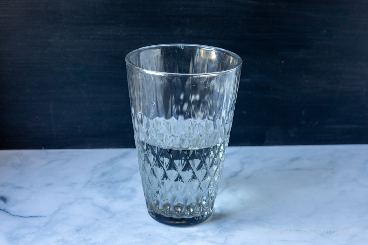 Large clear vase with 2/3 water.