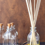 A homemade reed diffuser next to a couple of empty bottles.
