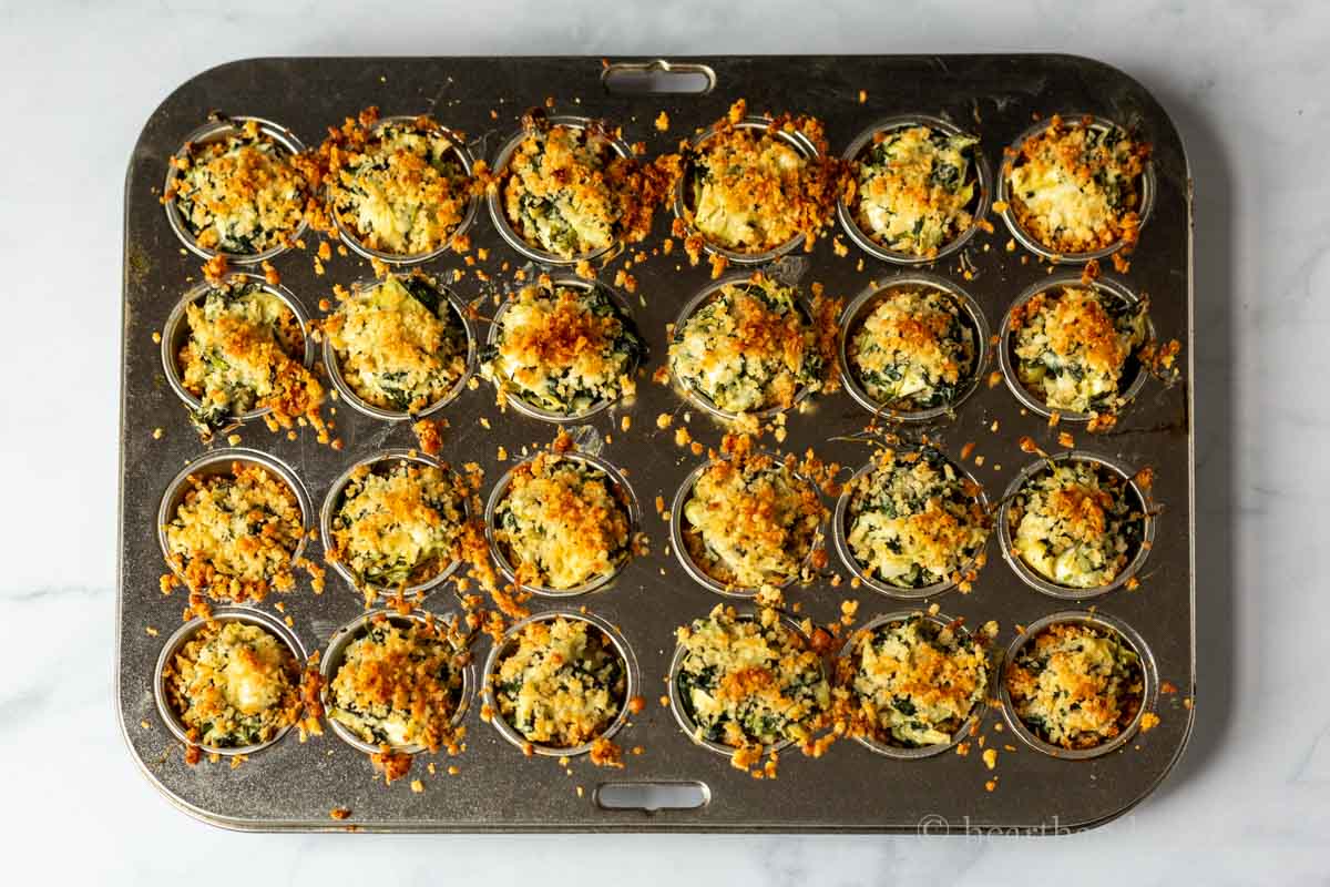 Spinach and artichoke dip bites in a mini muffin tray after baking.
