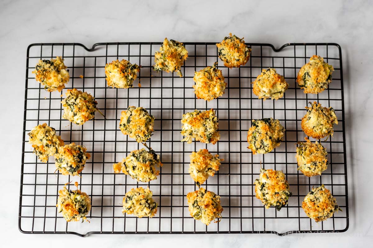 Spinach and artichoke dip bites on a cooling rack.