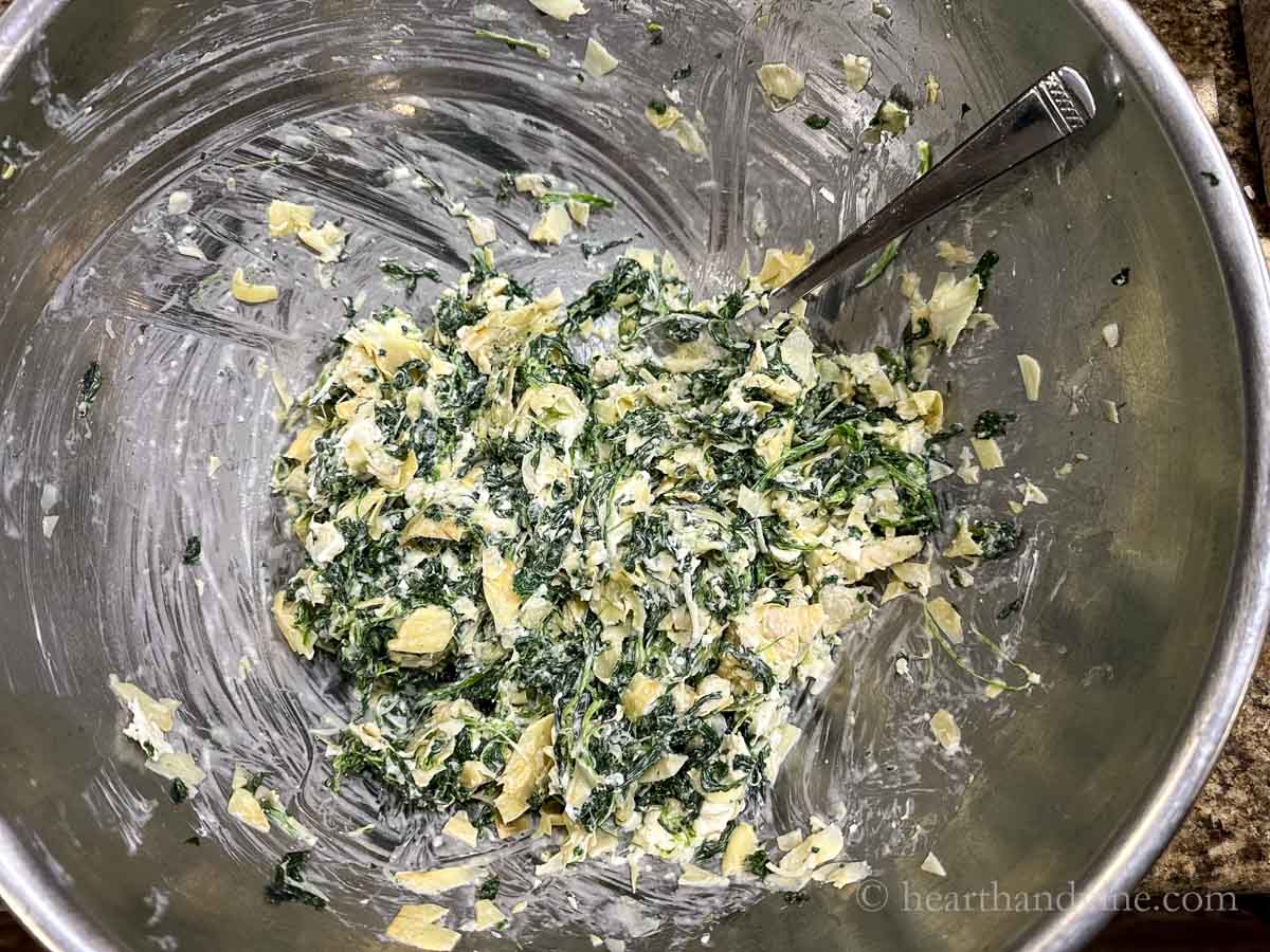 Spinach and artichoke dip in a mixing bowl.