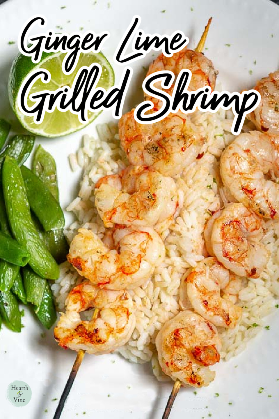 Grilled shrimp on wooden skewers over rice with snap peas and a half lime on the side.
