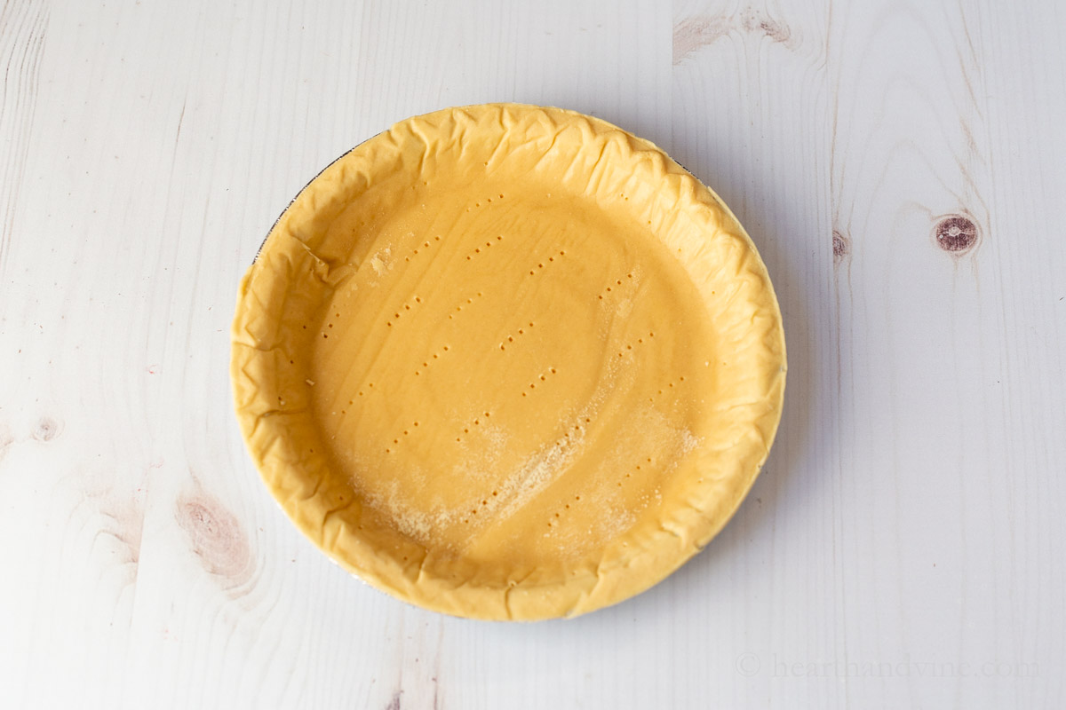 Pie shell pricked with a fork for baking.