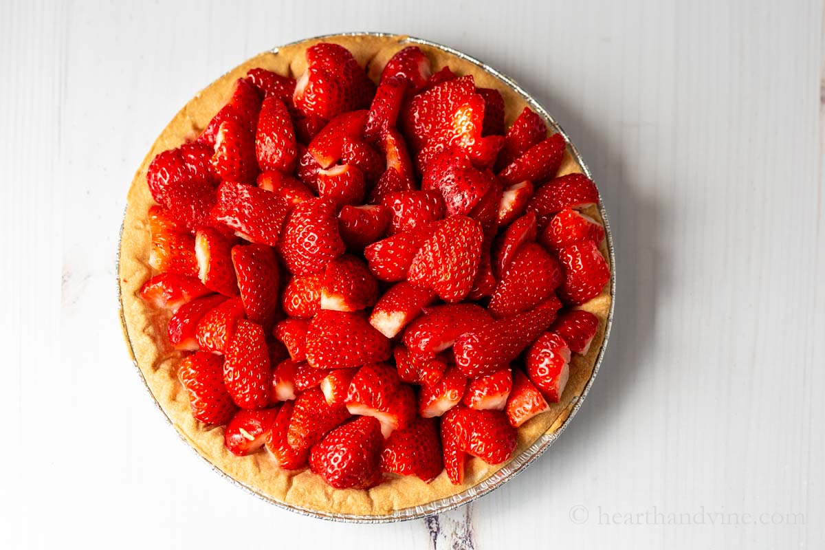 Strawberries cut and layered into a pre-cooked pie crust.