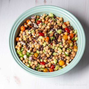 Dense bean salad in a light blue serving bowl.