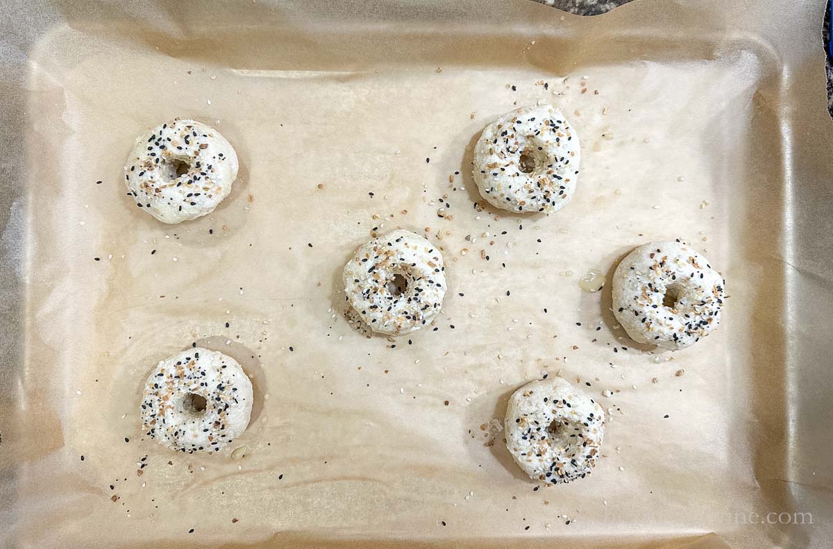 Everything bagel seasoning sprinkled on top of raw bagels.