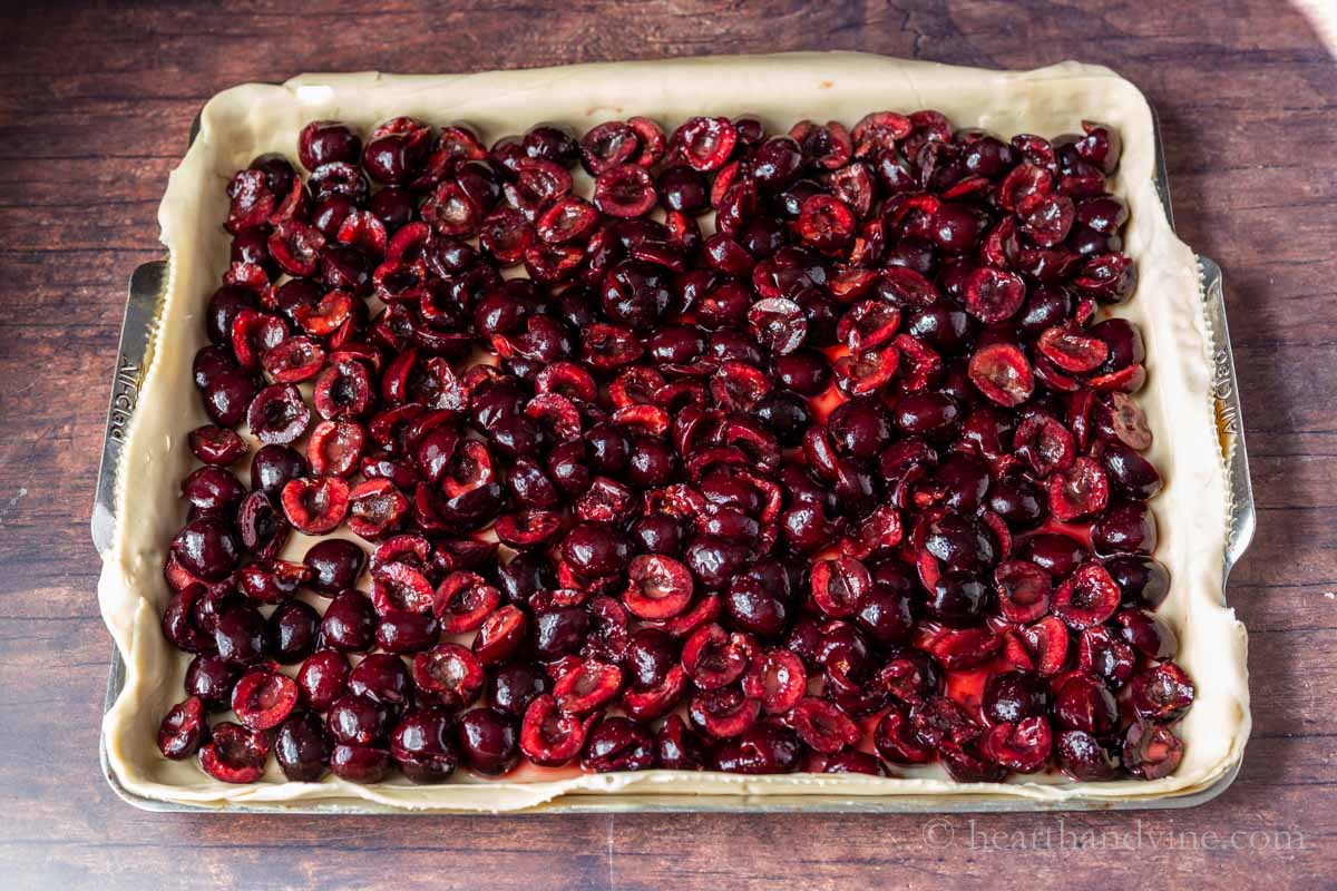 Cherry pie filling placed into a dough covered pan.