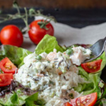 Fork taking a bite of a plated seafood salad.