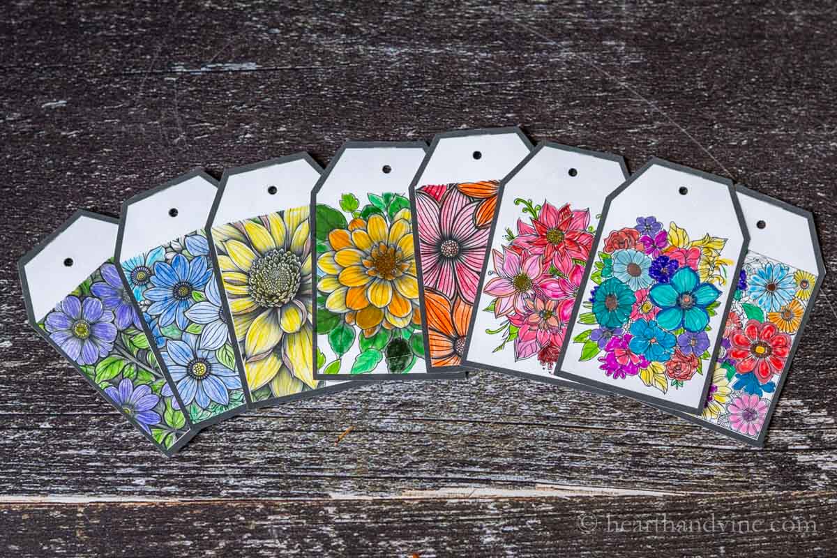 Eight hand-colored flower gift tags in a row.