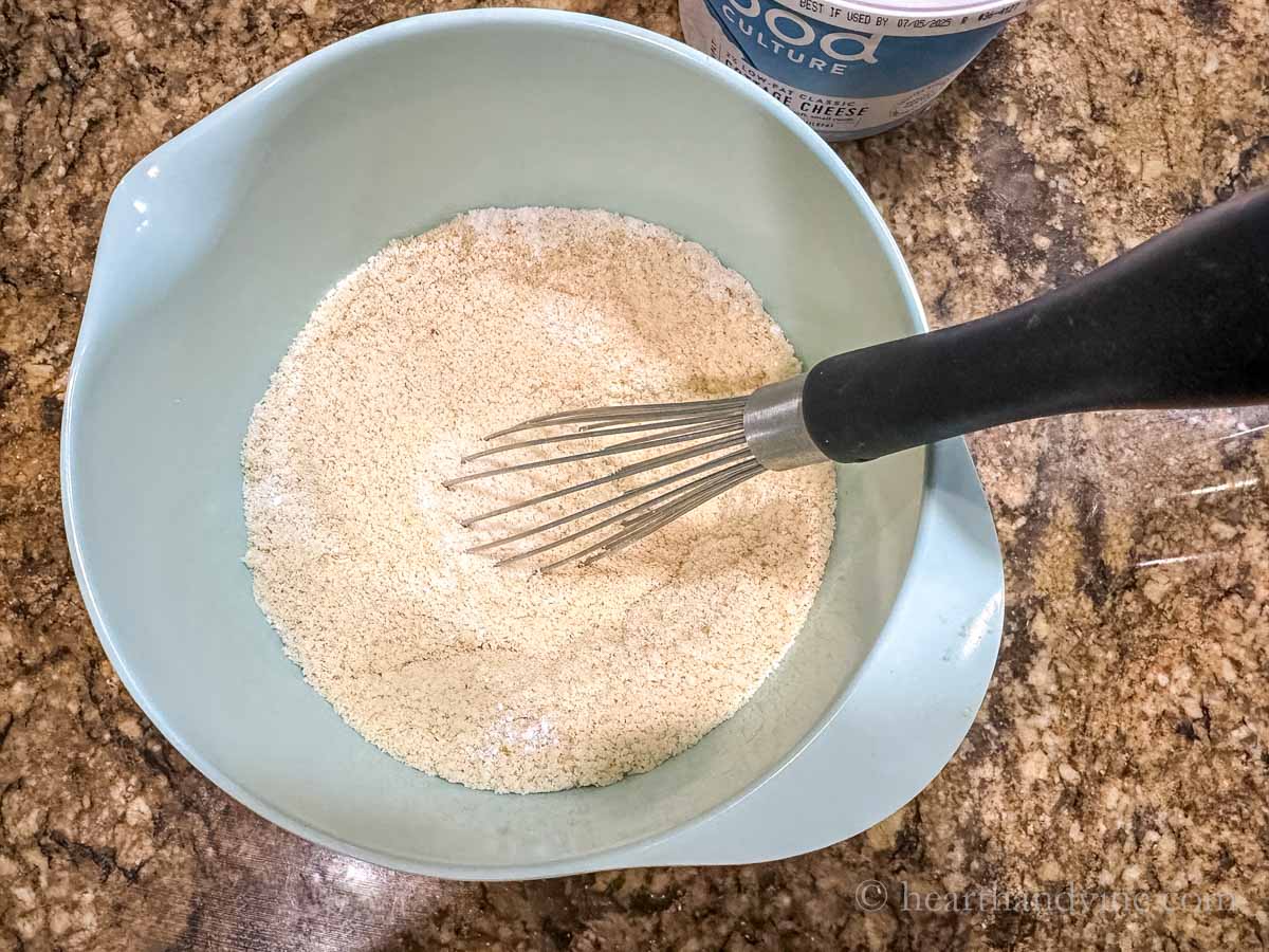 Whisking dry ingredients together in a medium mixing bowl.