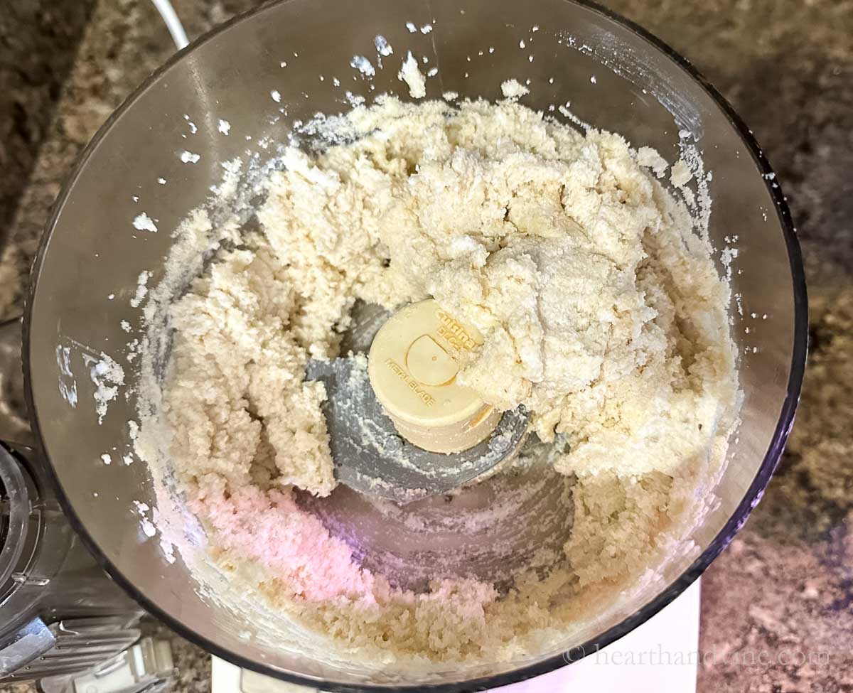 Adding dry ingredients to whipped cottage cheese in a food processor.