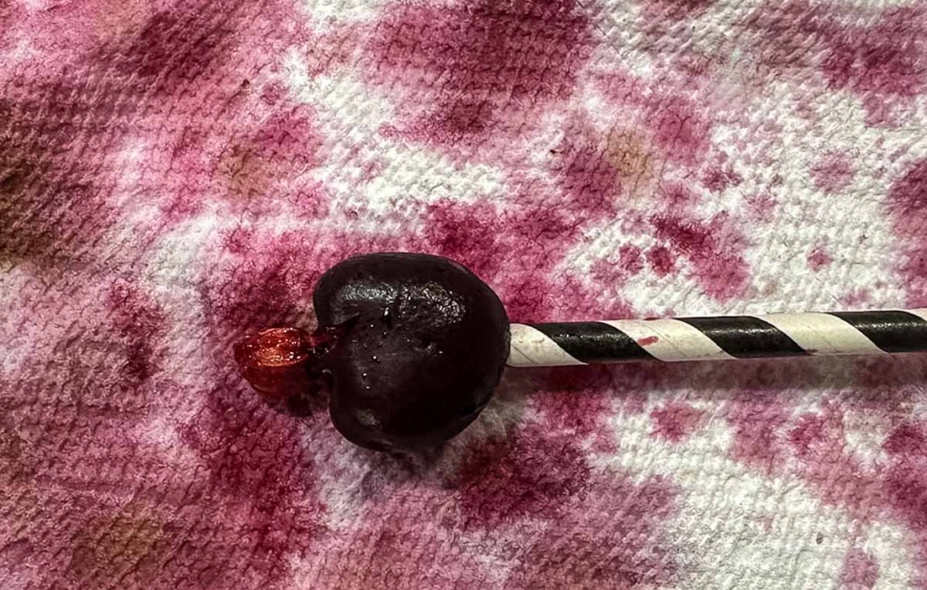 Pitting a cherry with a straw.