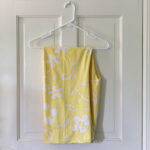 Pair of yellow floral PJ pants hanging on the back of a door.