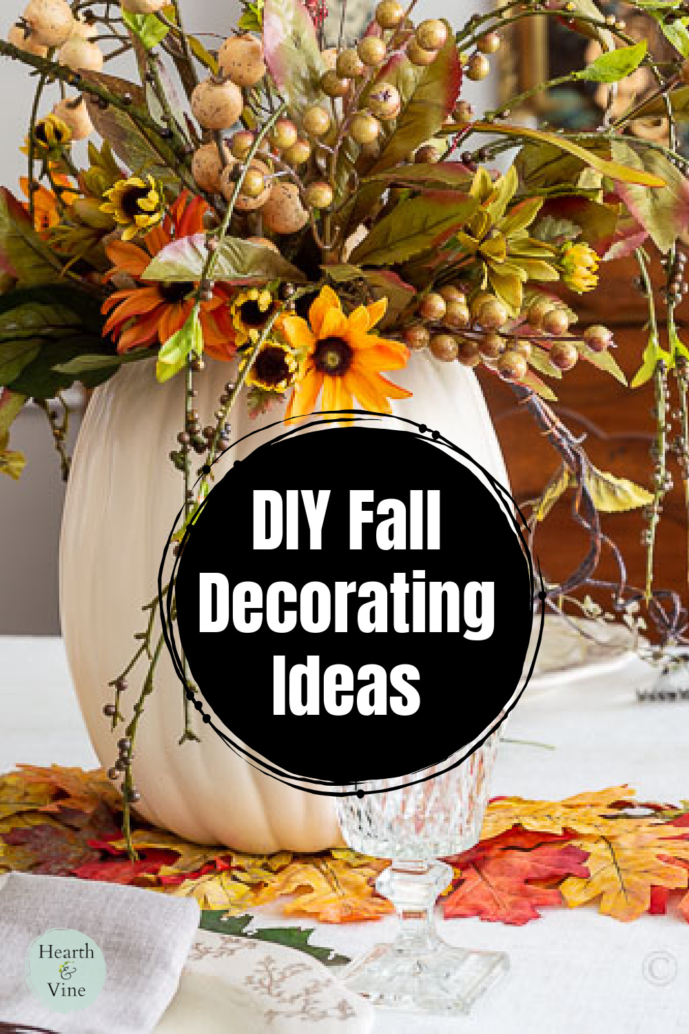 Large cream faux pumpkin with artificial flowers and berries arranged in the top for a pretty fall centerpiece.