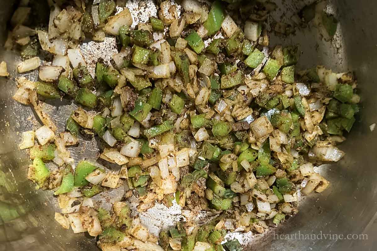 Onion, green pepper and spices sauting in a large pot.