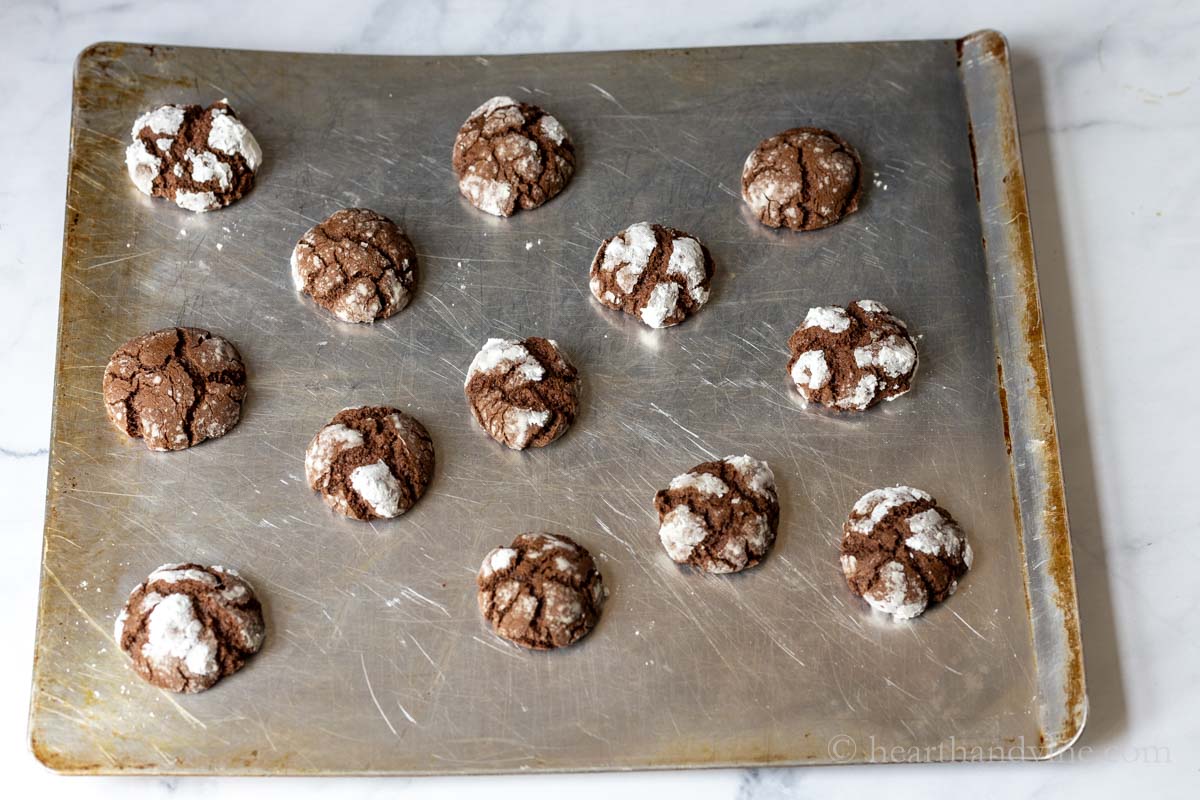 Cookie dough balls on a cookie sheet after baking in the oven.