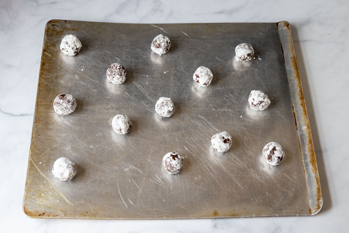 Cookie dough balls on a cookie sheet before baking.
