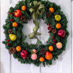 Williamsburg fruit wreath hanging on a white door.