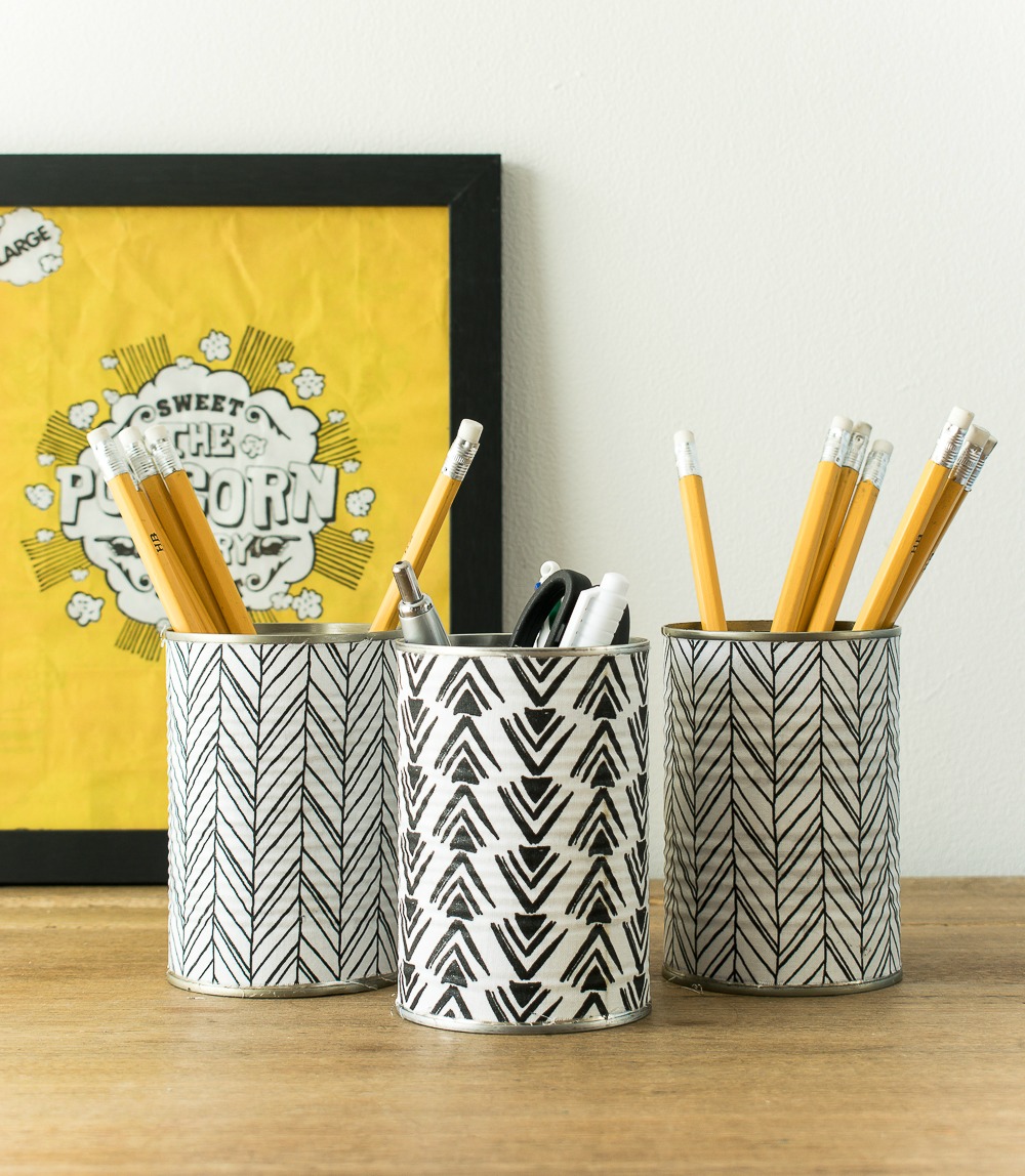 Three tin can pencil holders decorated in black and white.