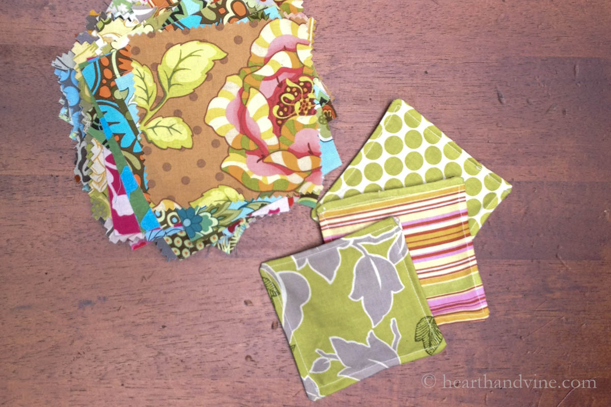 Three mug mats and a stack of colorful 5 inch quilters squares.