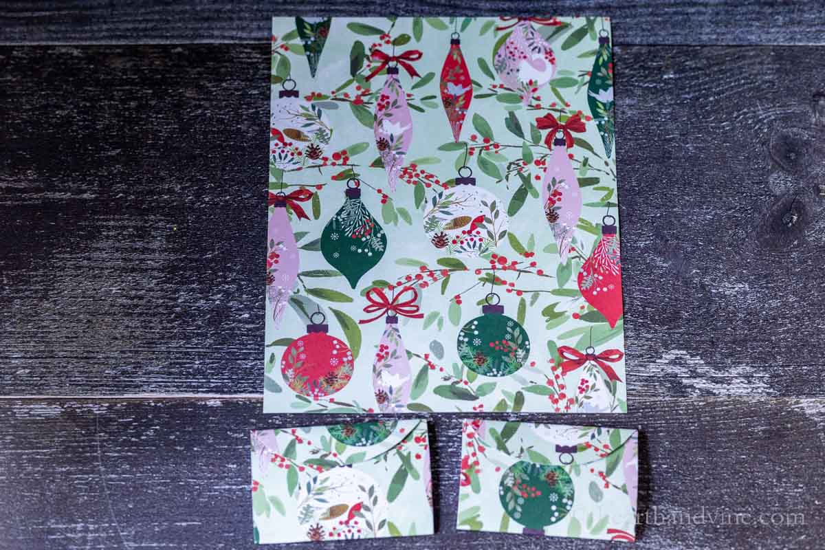 A 8.4 by 11 inch sheet of holiday scrapbook paper and two gift card holders from the same paper in different orientations.