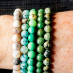 Five different healing stone bracelets on a wrist.