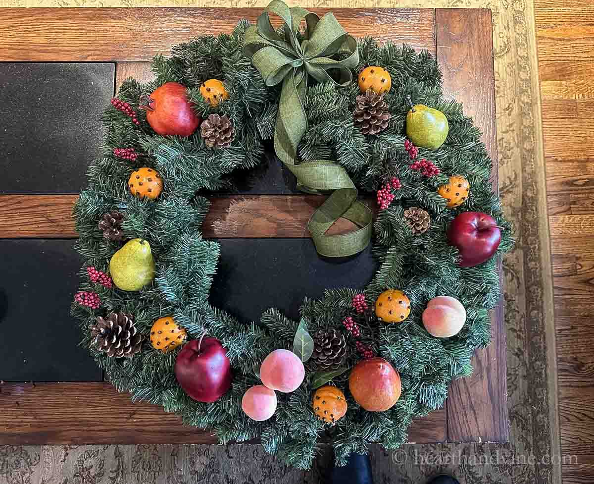 Large pine artificial wreath with faux fruit, pinecones, orange pomanders and berries.