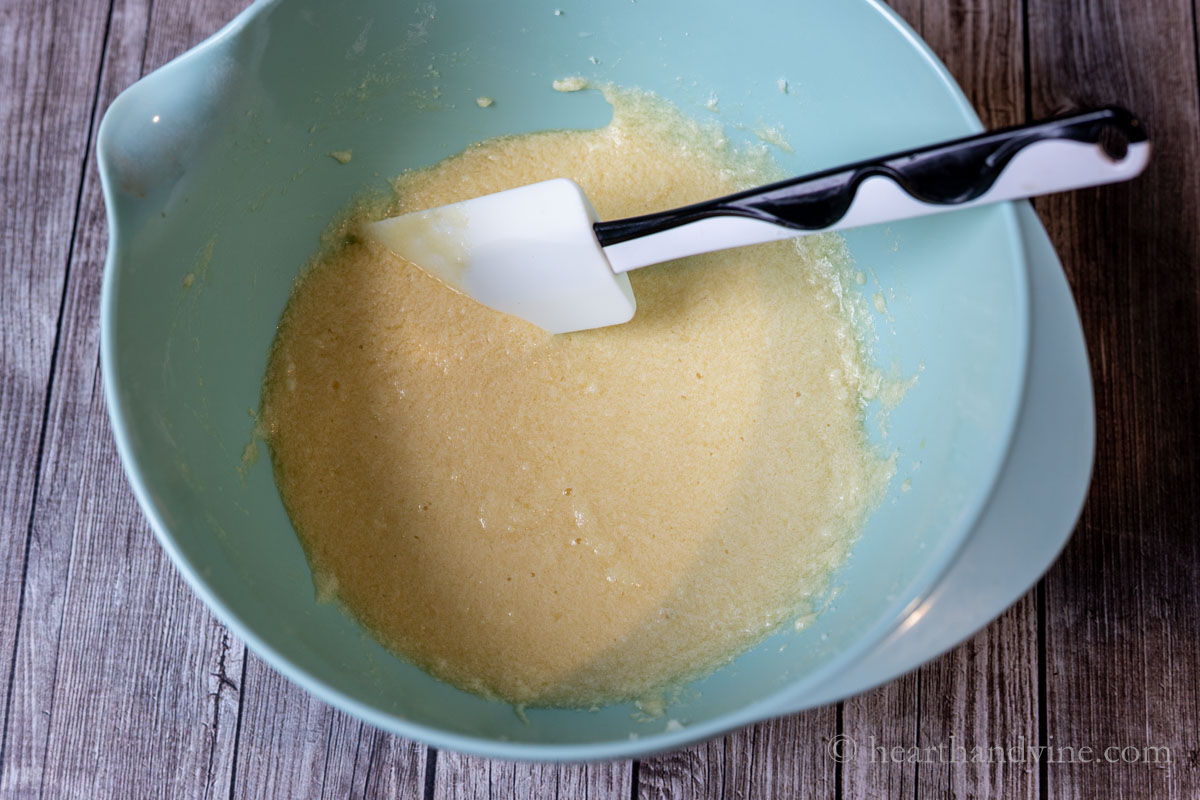 Wet ingredients in a large mixing bowl including butter, sugar, eggs, cider and vanilla extract.