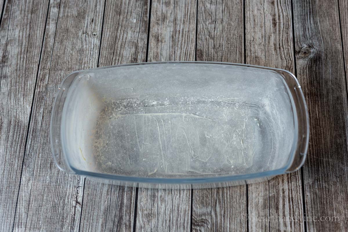 A greased and floured glass loaf pan.