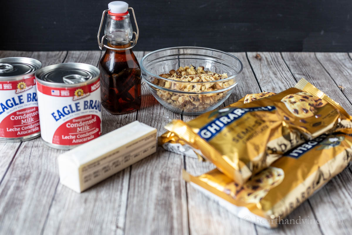 Fudge ingredients including, chocolate chips, sweetened condensed milk, butter, vanilla extract, and walnuts.