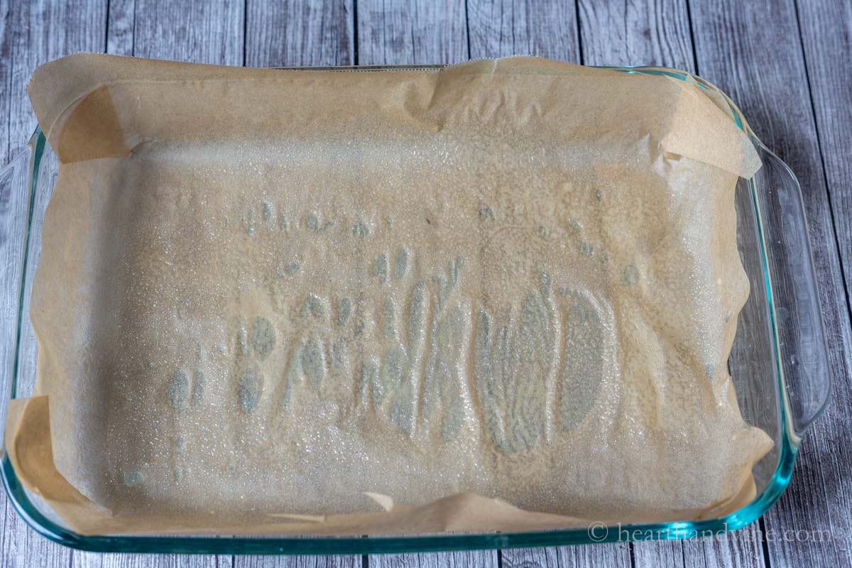 A parchment lined baking pan sprayed with cooking oil.