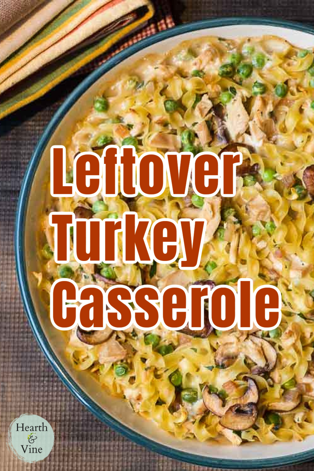 Partial view of a round casserole dish with leftover turkey, noodles, mushrooms and peas.