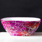 A small bowl with alcohol inks in pinks and purples.
