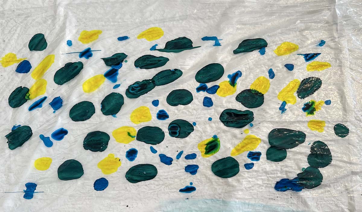 Drops of blue, green and yellow alcohol ink on plastic wrap.