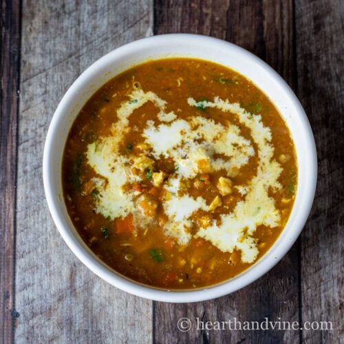 White bowl of butternut squash and chicken soup.