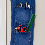 A hanging pocket organizer from jeans on a wall.