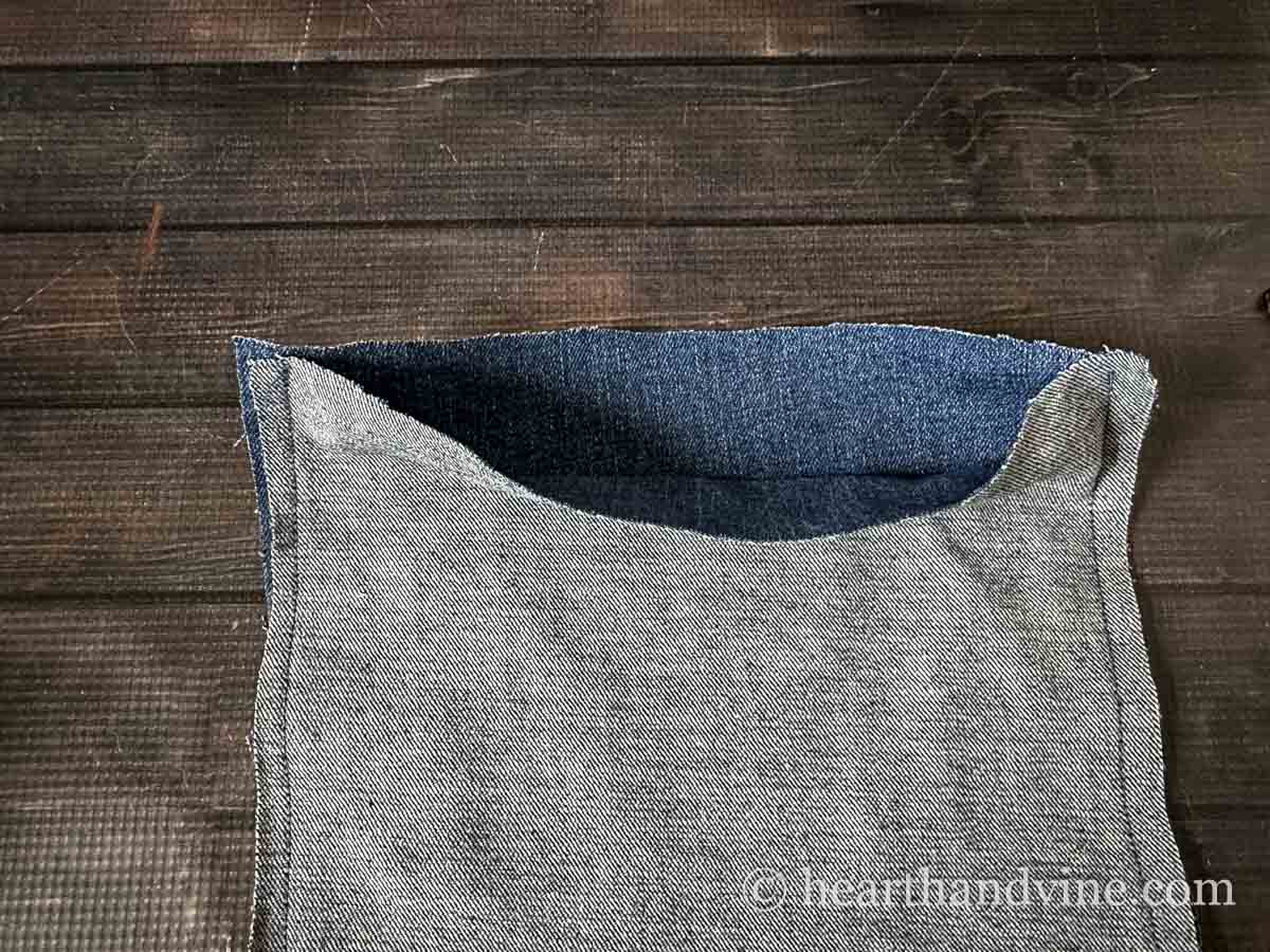 The open top of the denim rectangle sewn together.