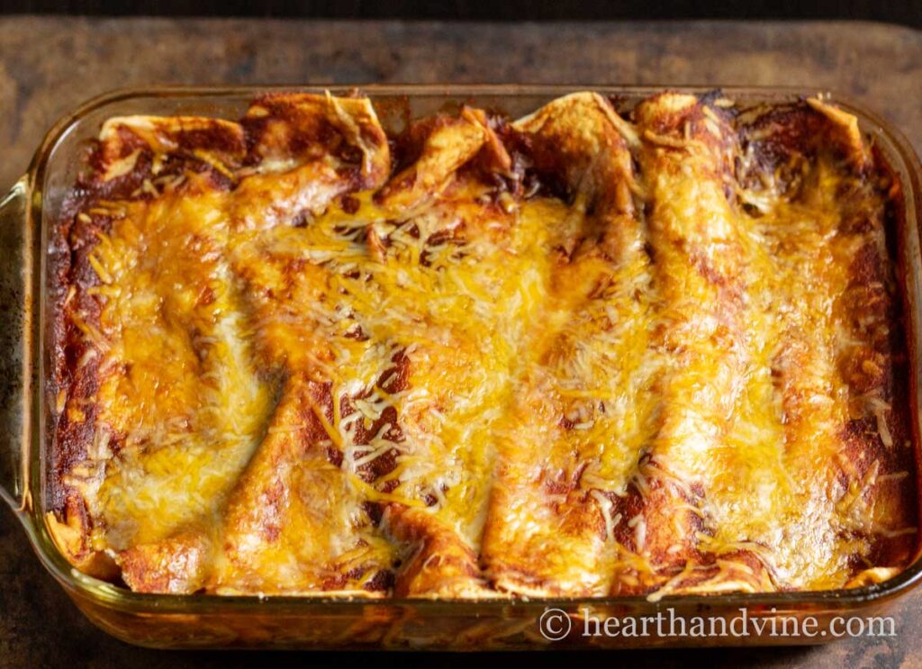 An aerial view of a pan of baked chicken enchiladas.