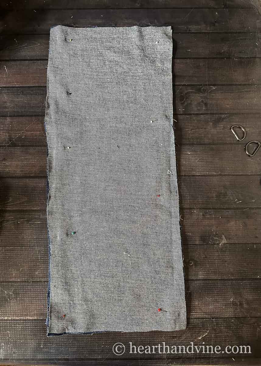Two long pieces of jean material in a rectangle placed right sides together and pinned into place.