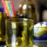 A single green drinking glass on a coaster.