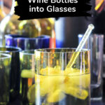 Glass made from a wine bottle with liquid, ice and a stirrer.